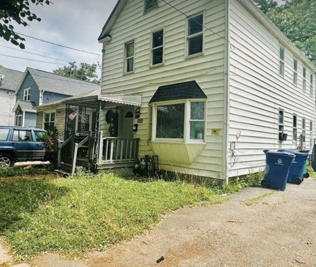 Cream coloured two-family rental property with a bay window in Buffalo, New York